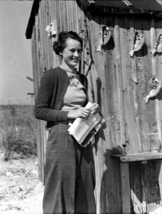 Young Elizabeth Taylor (later Turner) visiting a mullet fisherman's camp on Brown's Island (Onslow County), ca. 1939. She recalled the visit when I spoke with her. At that time, she was 99 years old but has since passed. we can see salted spots drying on the cabin wall behind her. Photo by Charles A. Farrell. Courtesy, State Archives of North Carolina