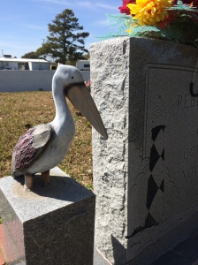 This woman's marker includes a wooden sculpture of a pelican and an etching of the Cape Lookout Lighthouse. A foot stone also refers to Genesis 31:49, which says, in part, "the Lord watch between me and thee, when we are absent from one another."