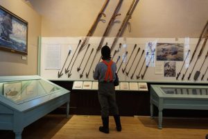 A visitor looks at the New Bedford Whaling Museum's collection of whaling harpoons. Courtesy, WBUR, public radio Boston.