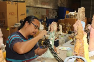 Conservationist Ben Caguioa working on one of Annie Hooper's Biblical figures in Wilson last summer. Photo by Lisa Boykin Batts, courtesy of The Wilson Times