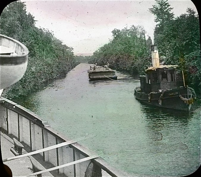 Tug Dauntless and lumber barge as seen from the bow of the lighthouse tender Violet, Albemarle & Chesapeake Canal, 1901. Image by Albert Ross, USN. Courtesy, Linda Garey