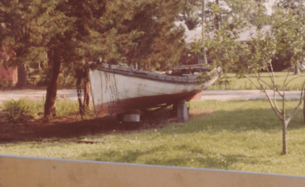 The Tom Dixon, a 28 and /12 ft. shad boat, in the backyard of Earl Willis, Jr.'s mother's house in 1980. George Washington Creef built her ca. 1891.  Mack Gaskill had given the boat to Earl in the 1970s. After H. R. Creef restored her, Earl donated the boat to the N.C. Maritime Museum in Beaufort, N.C. Photo by Mike Alford