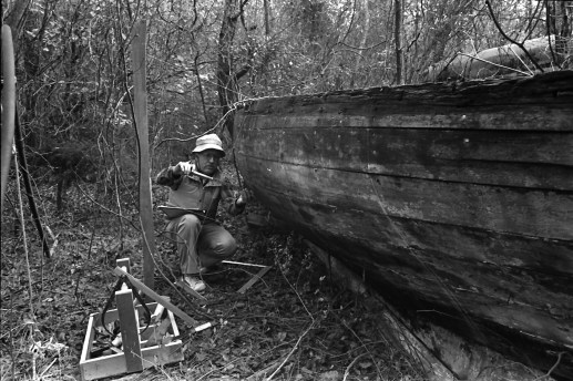 Mike Alford recording the construction details and midship section shape of a shad boat found in the woods on the north side of Roanoke Island probably in the 1980s. Courtesy, Mike Alford 