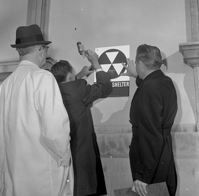 Men posting a nuclear fallout shelter sign on one of Greenville's public buildings. Courtesy, Joyner Library, ECU