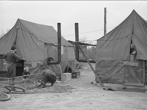 Family at a migrant camp of Ft. Bragg construction workers at a tent camp near Fayetteville, 1941. They rented tent space for $1.00 a week. Photo by Jack Delaney. Courtesy, Library of Congress