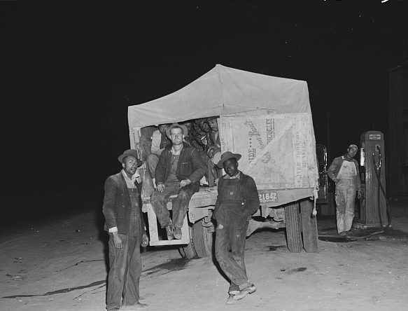 Other construction workers commuted long distances to Ft. Bragg. Shown hear getting gas at a country store in Manchester, these men commuted daily from Greensboro, 90 miles away. Their truck holds 20 or more men. Note they include white and black workers: racial mixing that would have caused riots in Greensboro was standard stuff in the great maelstrom that was World War II in eastern N.C. Photo by Jack Delano. Courtesy, Library of Congress