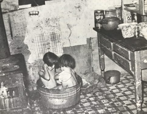 Saturday night bath in the kitchen. Photograph used in Sharecroppers: The Way We Really Were. Courtesy, Library of Congress.