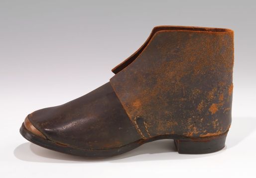 Brogans may have been going out of fashion in Elizabeth City, but practically every rural working man and many a woman in eastern N.C. still wore them. They were heavy, ankle-high work boots, made of coarse, untreated leather and with a nailed or pegged sole. They were the archetypical footwear of soldiers, slaves and working people and their use dated back to the British Isles as early as the 16th century. The name "brogan" apparently derives from an Old Irish or Scotch word for shoe. This brogan is actually in the collection of the Metropolitan Museum of Art in New York City.