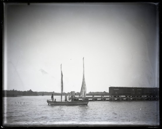 Fishing boat, probably a pound or gill netter, coming into railroad wharf in Edenton, N. C., 1881. We can see a Norfolk & Elizabeth City RR freight train on wharf in background. Smithsonian Institution Archives, Acc. 11-006, Box 015, Image No. MAH-4920