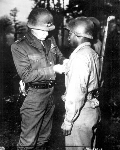 Lt. Gen. George S. Patton pins the Silver Star on Pvt. Ernest A. Jenkins on Oct. 13, 1944, in recognition of his heroism during the liberation of Chateaudun, France. Overall more than 1.2 million African American men and women served in the American military during WWII. Photo courtesy, National Archives