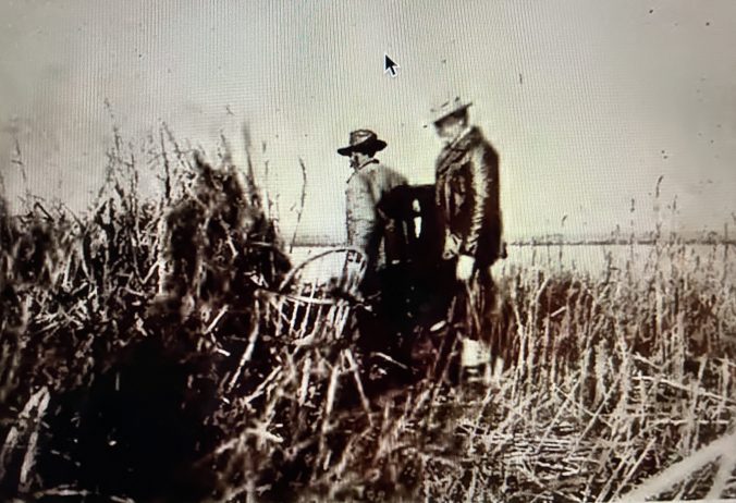 A hunter from Boston and his local guide Sam McHorney enter a marsh blind at Pine Island, ca. 1916. From Sam Baum, "A History of Market Hunting In the Currituck Sound Area, Part 1," in Wildlife in North Carolina (Nov. 1968).
