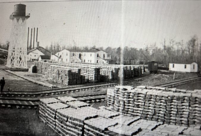 The John L. Roper Lumber Co.'s juniper (Atlantic white cedar) mill in Roper, 10 miles north of the Pungo River's headwaters. Moving left to right, we can see the mill's water tower, power plant, the cedar sawmill, loaded railroad cars, and the spur of the Norfolk & Southern's Main Line that led into the mill. On the near side of the tracks, we can see stacks of cedar shingles and laths. American Lumberman, April 27, 1907.