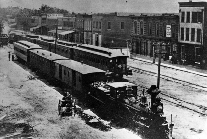Goldsboro in 1890 was a railroad town, where three major railroads met and passengers often changed trains. Downtown (seen here ca. 1870) was filled with locomotive smoke, the sound of railroad whistles, and passengers from near and far. Courtesy, CP&L Photo Collection, State Archives of North Carolina