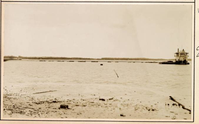 In this photograph, dated Sept. 1931, we can see a different kind of dredge boat, a plain suction dredge, at work on North River, just east of Beaufort, N.C. She is making or maintaining a channel, presumably one mainly for the use of commercial fishing boats. The dredge may have been the Neveral, which seemed to do the bulk of the harbor dredging in and around Beaufort and Morehead City in the 1920s and early '30s, including the dredge work necessary to build the new bridge between the two towns. At this date, she was owned and operated by the Coastal Construction Co., but was under contract to the Corps of Engineers. As we can see, her crew has laid piping along a series of pontoons to transport the dredge spoil to land. Source: Office of History, HQ, U.S. Army Corps of Engineers 