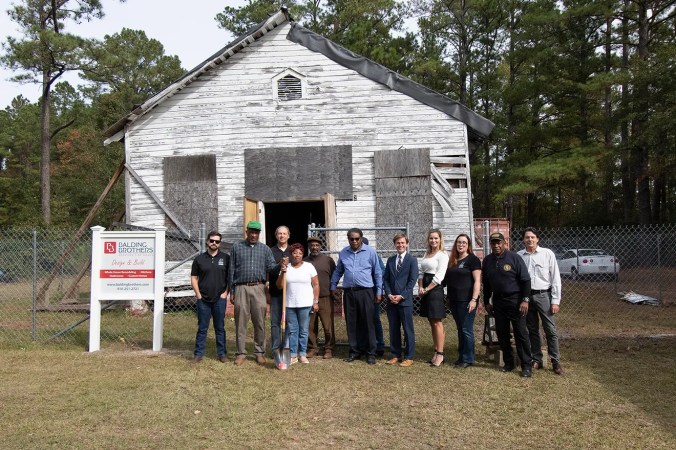 On Nov. 10, 2001, community partners from the Cedar Hill/West Bank Heritage Foundation, the N.C. Coastal Land Trust, the Historic Wilmington Foundation, and the Balding Brothers gathered at Reaves Chapel to mark the formal beginning of church's restoration. Photo by Walker Golder. Courtesy, Wilmington Star-News