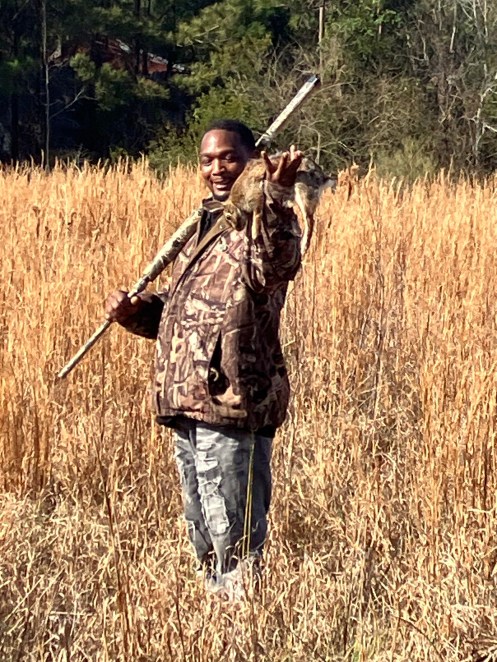 The guys did a little hunting when the opportunity presented itself. Nick Smith got the second rabbit of the day in a meadow by one of the community's old swim holes. Photo by David Cecelski