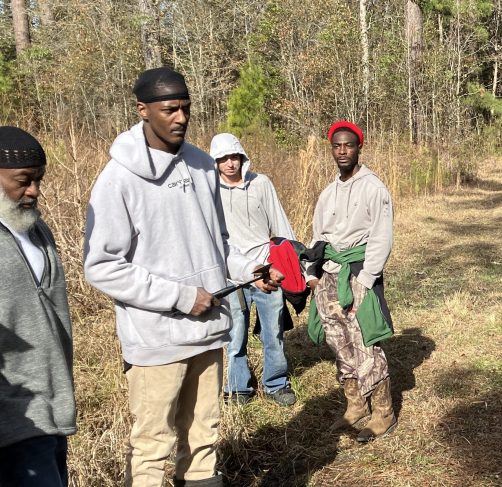 (Left to right) Vinnie Joyner, Joshua Tooley, Travis Thompson, and Don Hardy, Jr. were usually helping to lead the way, but here they've stopped to listen to Marion tell a story. Photo by David Cecelski