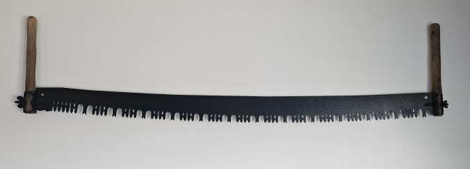 One of his great-grandfather's 2-man crosscut saws hangs in Josh's living room. Photo courtesy, Josh Powell